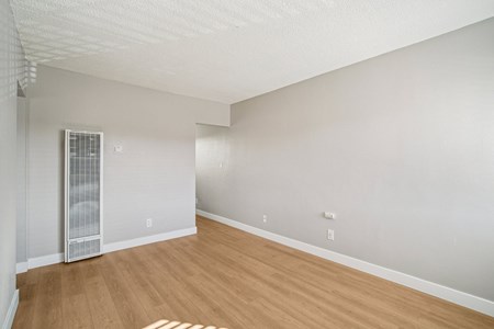 A room with a wooden floor and a white ceiling with a window.